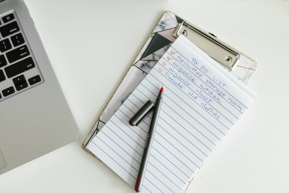 A neatly organized to-do list on a clipboard next to a laptop and pen, conveying productivity.